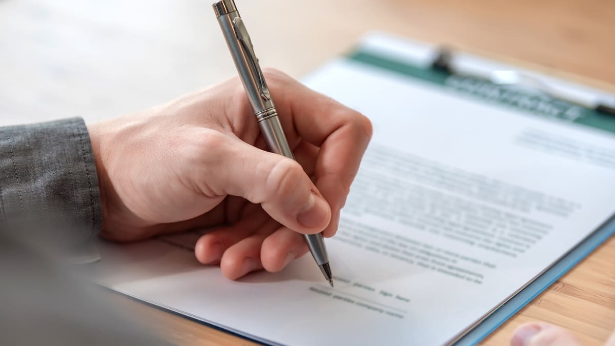 Close up of a hand signing a paper
