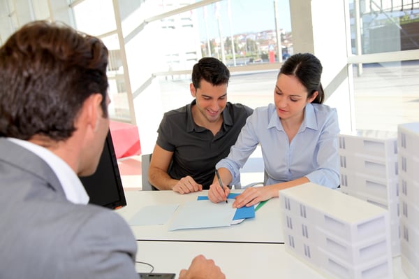 A man and a woman signing paperwork