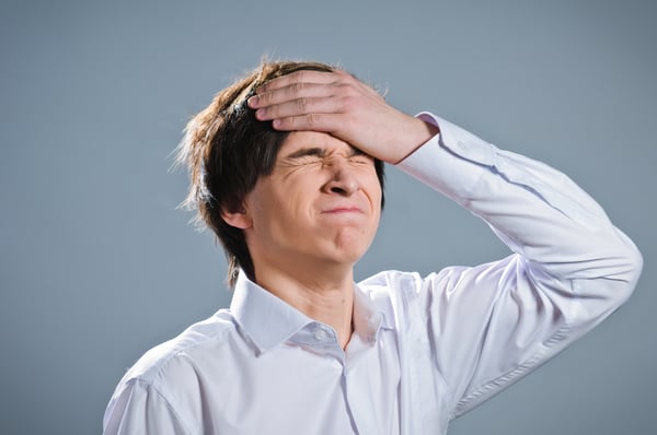 stressed out thinking about mistake with hand on forehead