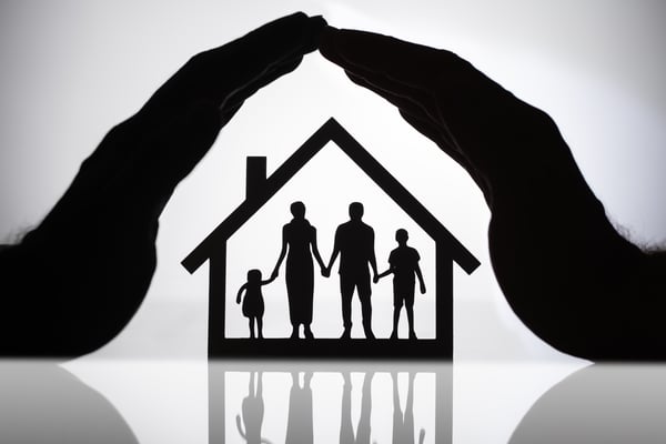 family with children silhouette inside black house outline