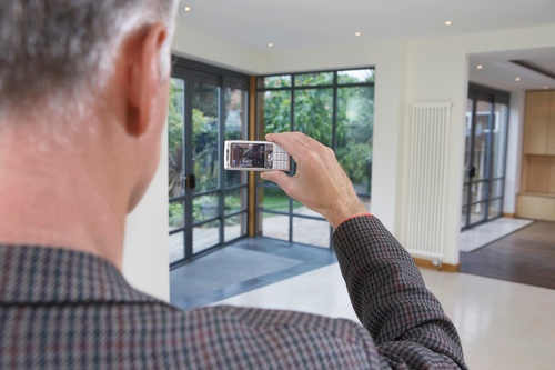male taking photo of property indoors using a mobile phone