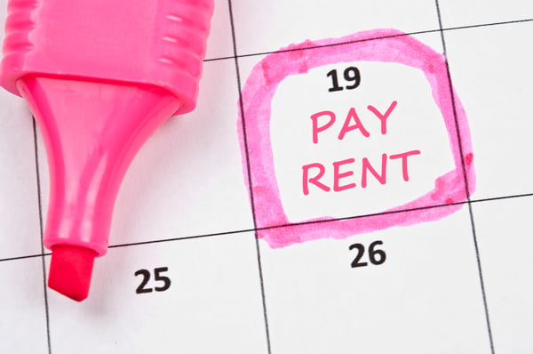 A calendar with a pink marker circling a date and "Pay Rent" is written on that date
