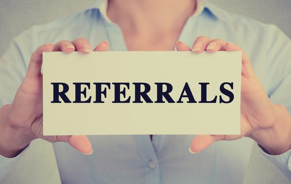 Person holding paper with "REFERRALS" on it