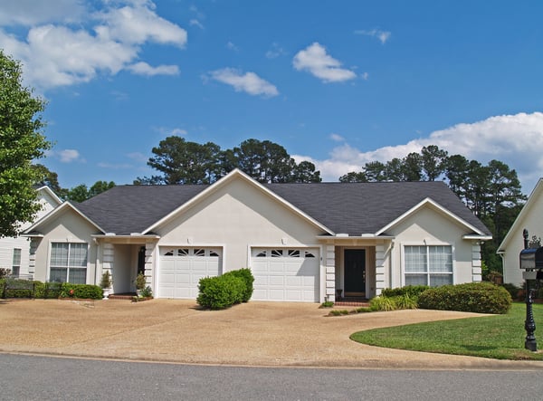 New low income small one story white vinyl duplex unit with garages in the front