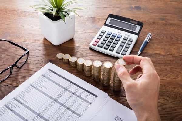 Person Stacking Coins On Desk