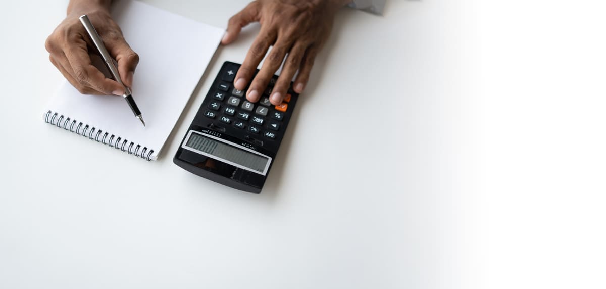 Someone with a calculator, paper, and pen