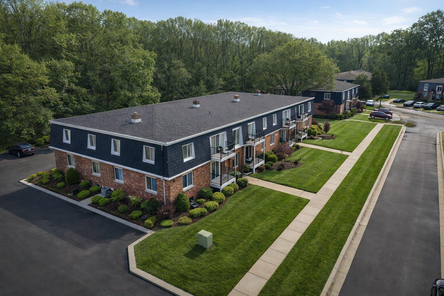 Aerial view of a brick and slate-blue building with balconies and manicured lawns at Z on Plymouth