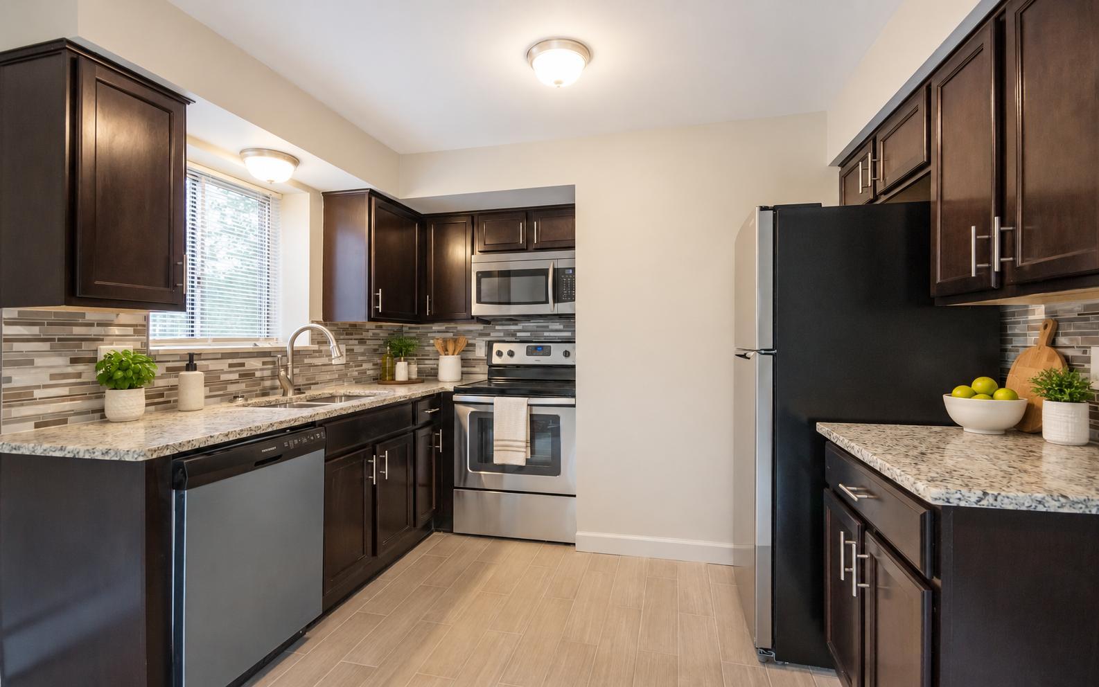 Kitchen with espresso shaker cabinets, granite countertops, glass tile backsplash and stainless steel appliances