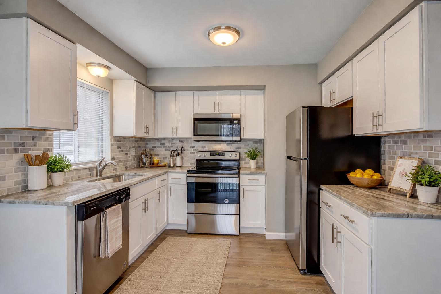 Updated kitchen with white shaker cabinets, granite countertops, marble subway backsplash and stainless steel appliances