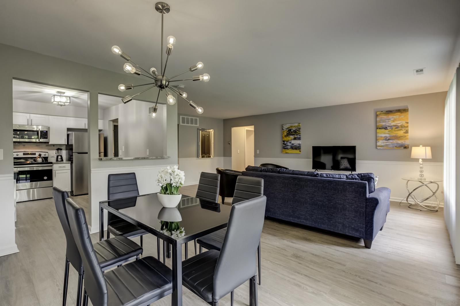 Dining area with a starburst chandelier, open to the living room and kitchen