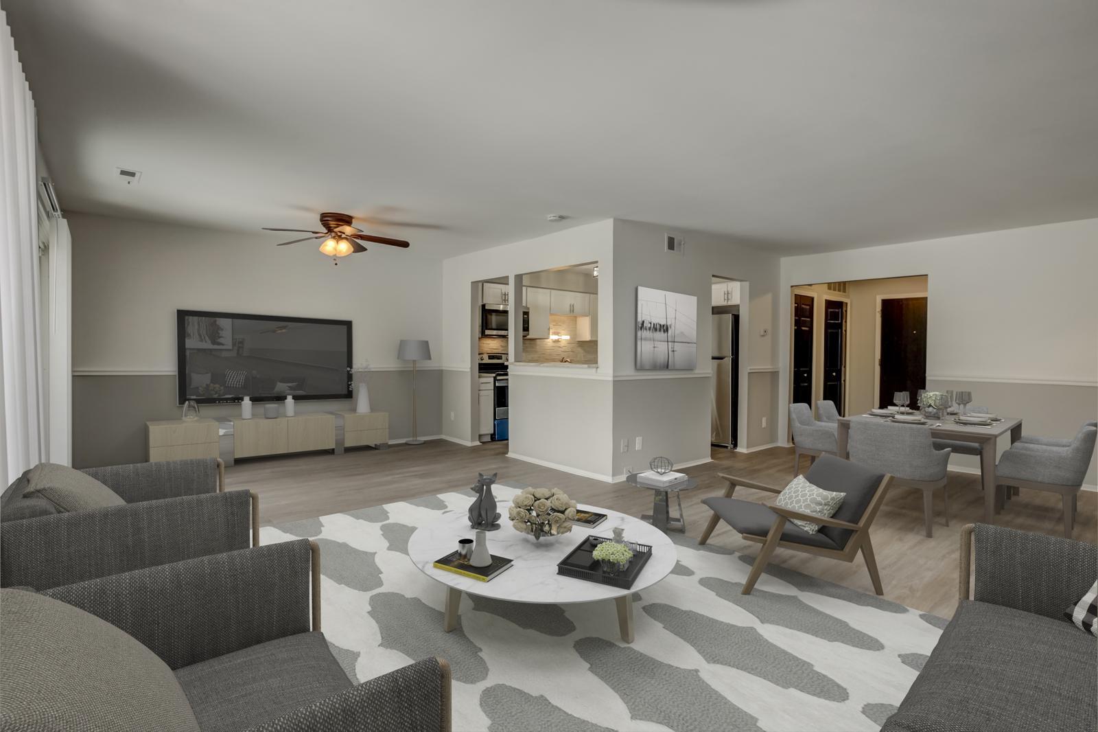 Open living room with a ceiling fan, kitchen pass-through and dining area
