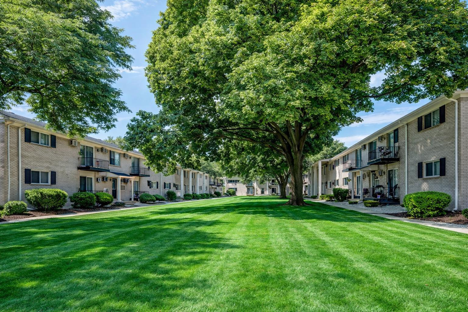 Z on Pardee tan brick two-story buildings facing a wide striped lawn courtyard under mature shade trees